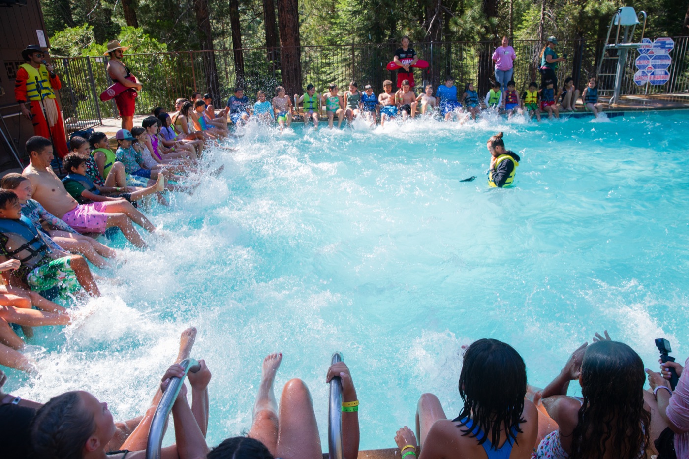 Campers cheering in the pool at Wagon Train, water flying.
