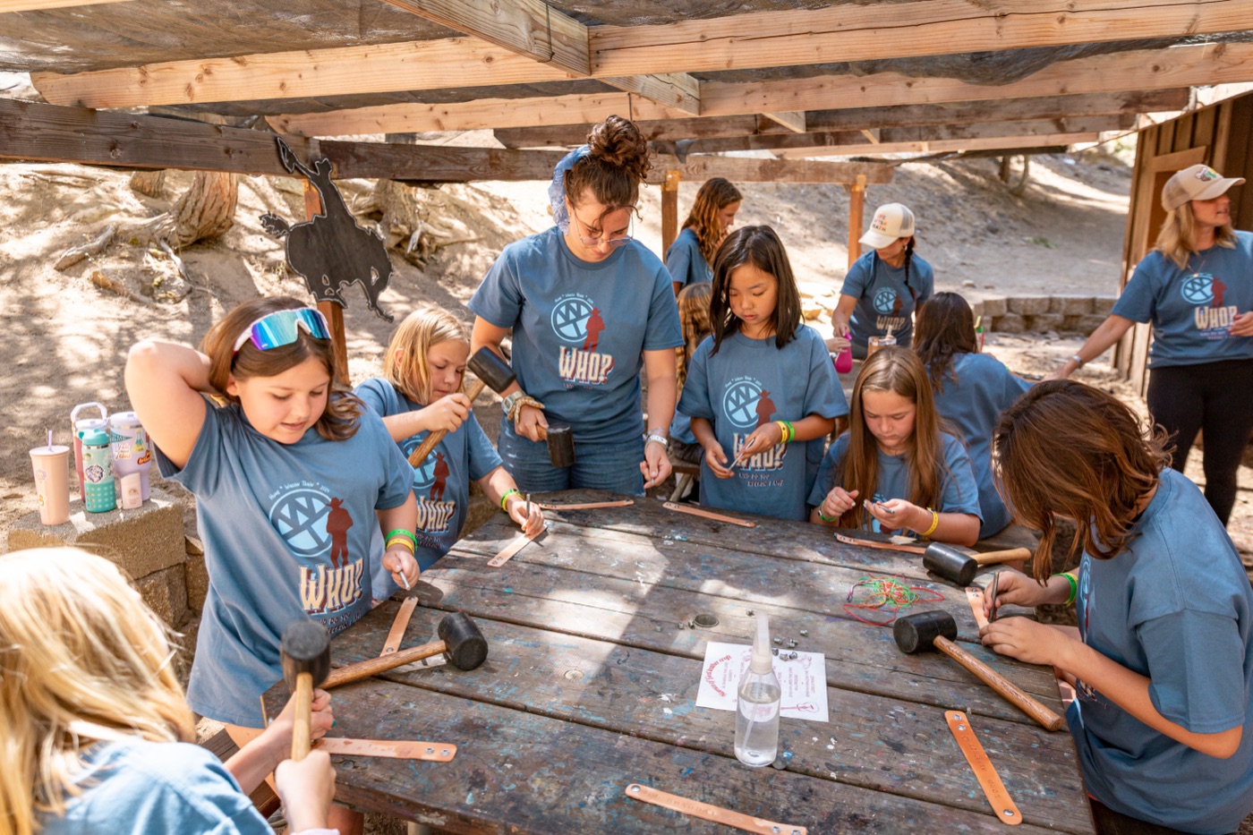 Campers making crafts at a wooden table at Wagon Train.